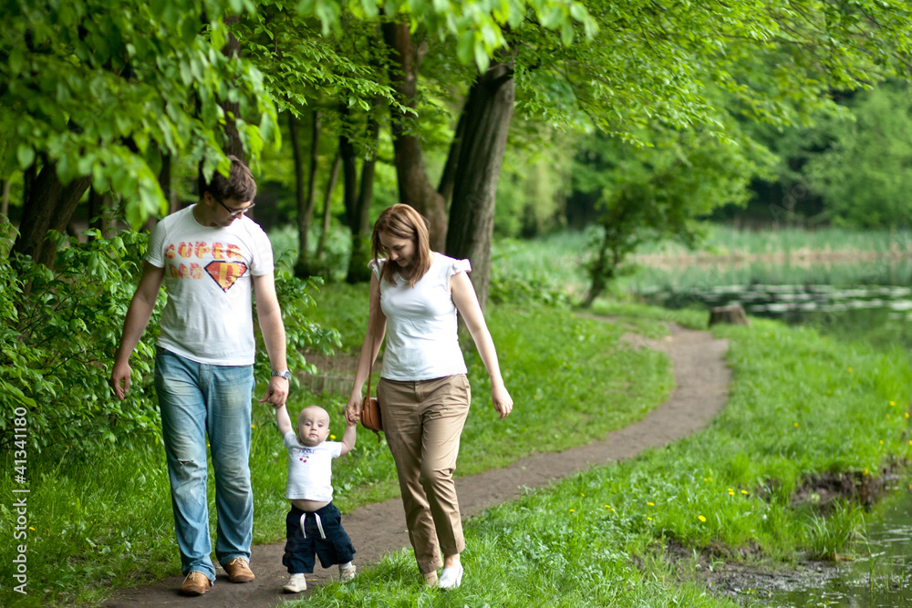 Fototapeta premium Portrait of happy young family with baby boy in spring park