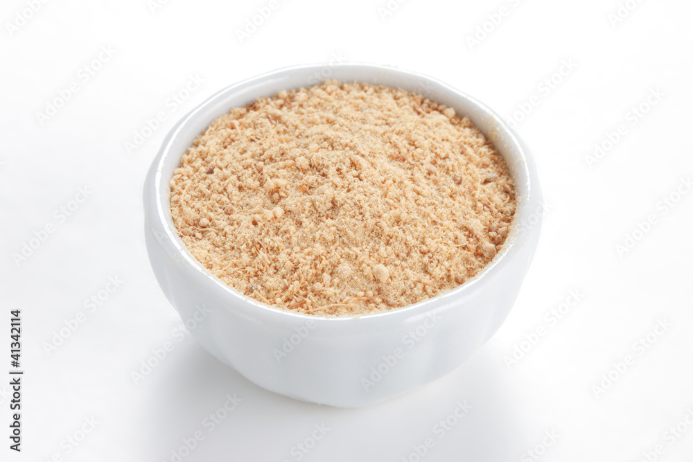 Ground Ginger (Zingiber officinale) in a white bowl on white bac Ground Ginger (Zingiber officinale) in a white bowl on white bac