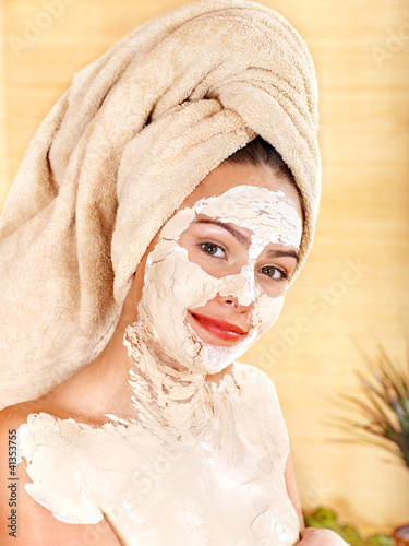 Young woman  having clay body mask.