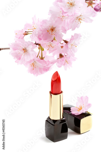 Natural cosmetics concept: new lipstick with sakura flowers, iso
