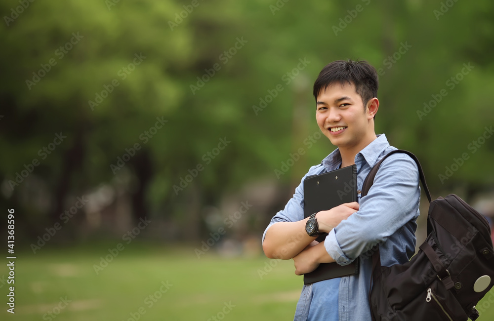 college student holding book on the park college student holding book on the park