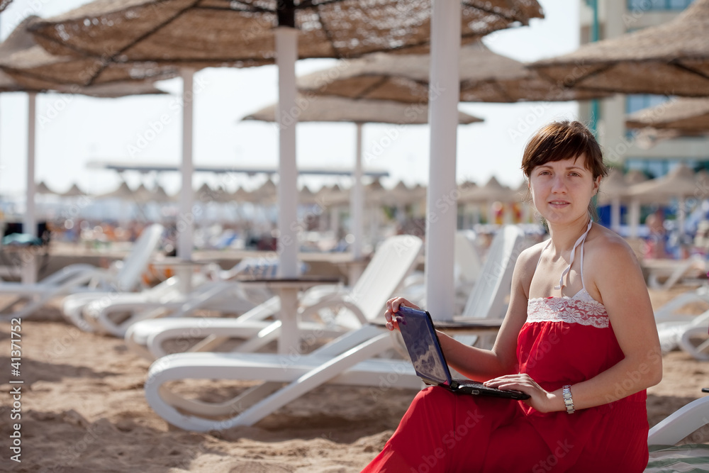 woman using  laptop at resort beach
