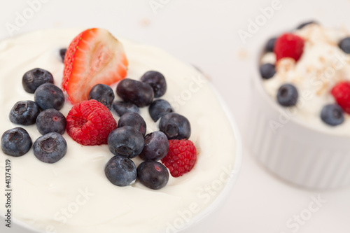 Bowl of cream with different berries