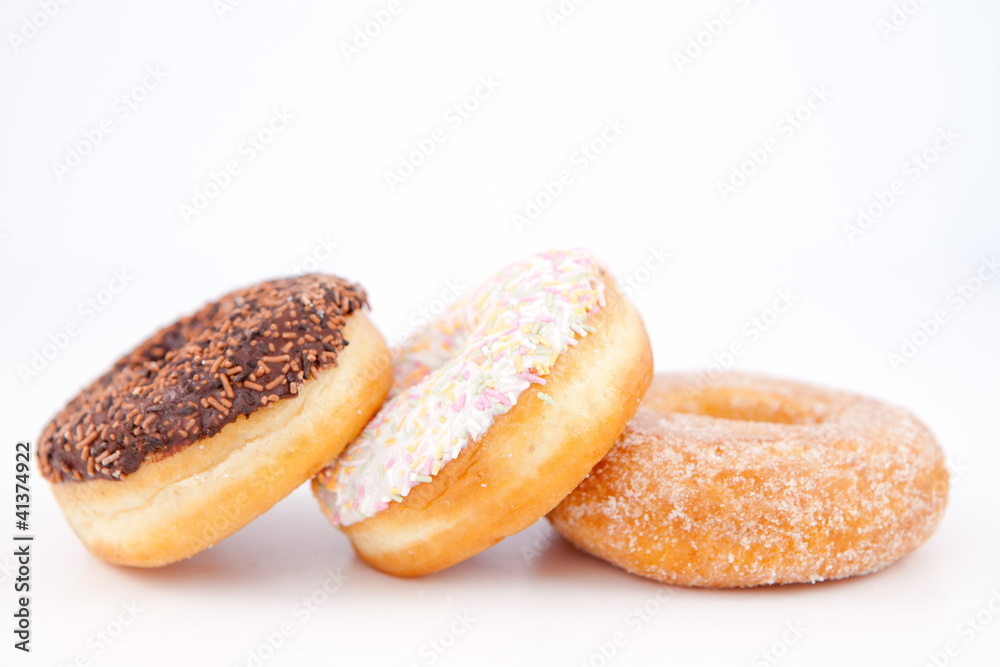 Three doughnuts with icing sugar lined up Three doughnuts with icing sugar lined up
