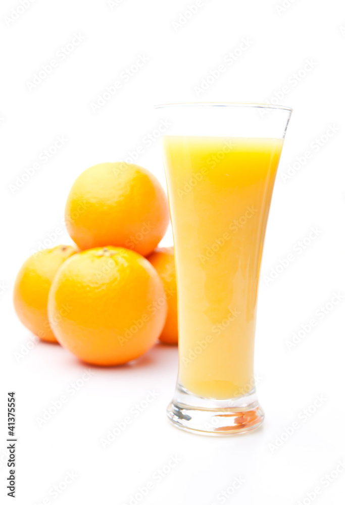Heap of oranges behind a glass of orange juice Heap of oranges behind a glass of orange juice