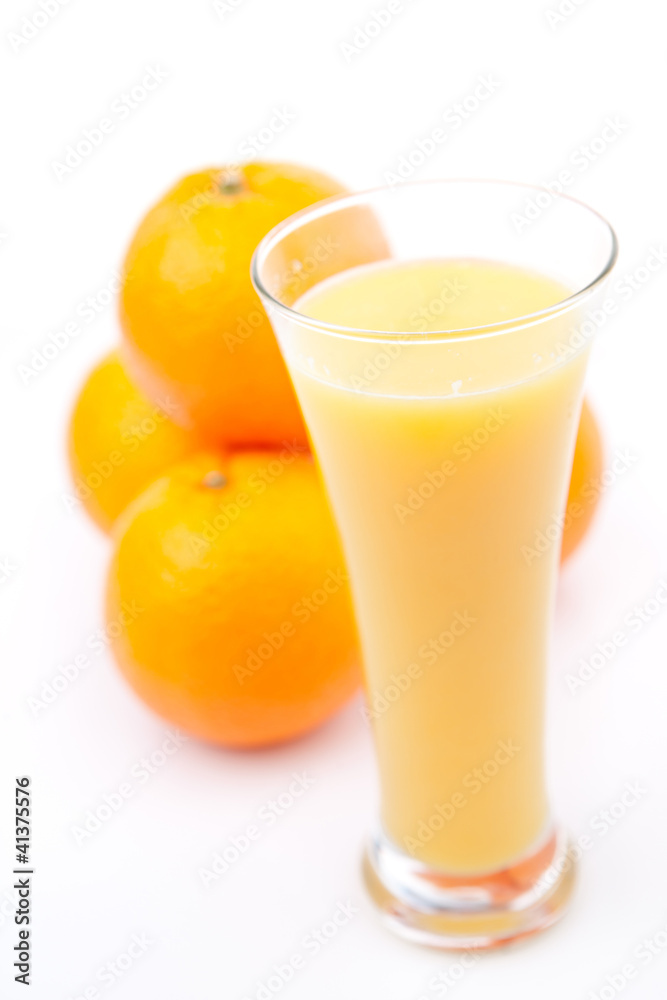 Oranges behind a glass of orange juice Oranges behind a glass of orange juice
