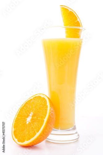 Half of am orange near a glass of orange juice