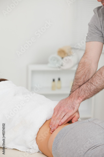 Woman lying while a physiotherapist is massaging her back