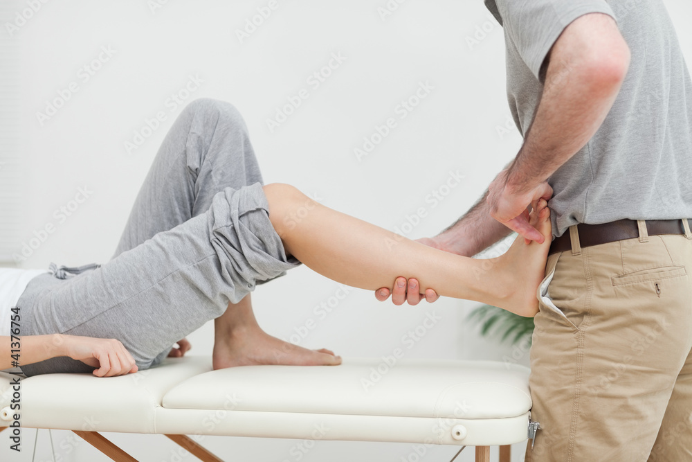 Close-up of a physiotherapist stretching the foot of a patient Close-up of a physiotherapist stretching the foot of a patient