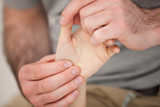 Physiotherapist palpating the fingers of a patient