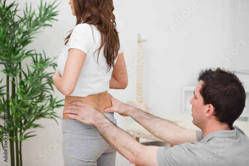 Картината върху платно Doctor sitting while examining the hips of a woman