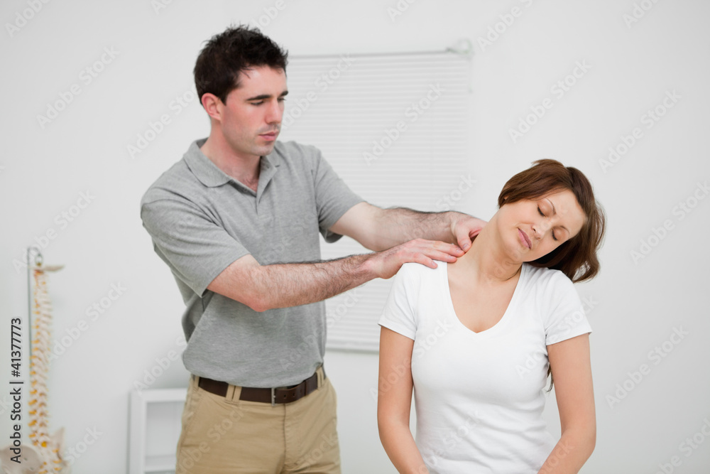 Practitioner looking at the neck of a patient Practitioner looking at the neck of a patient