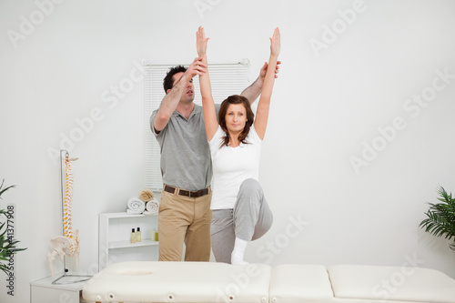 Brunette doing stretching exercises with a physiotherapist