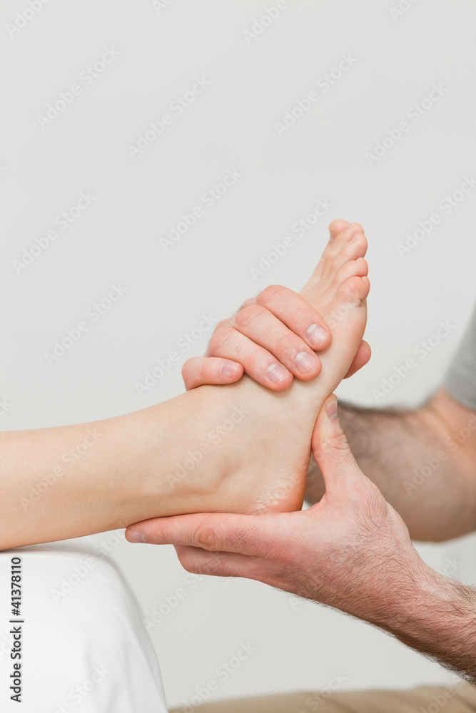 Fototapeta premium Hands of a physiotherapist massaging a foot