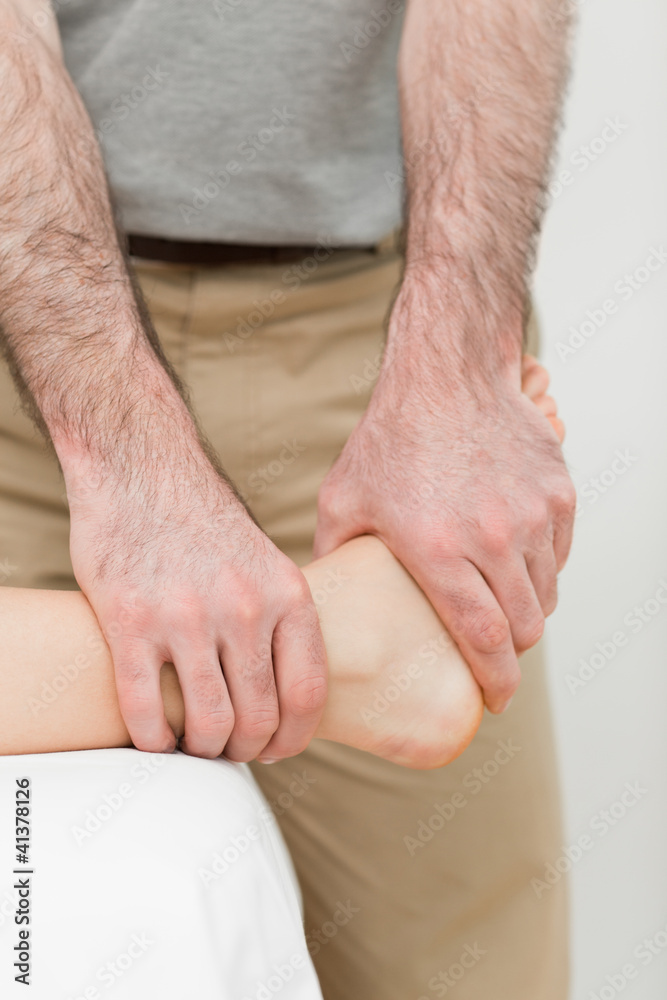 Osteopath manipulating the ankle of a patient Osteopath manipulating the ankle of a patient