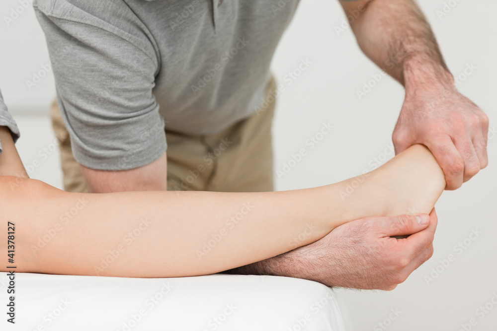 Physiotherapist stretching the ankle of a patient