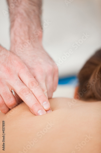 Doctor using his finger to massaged the back of his patient