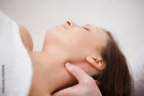 Close-up of physiotherapist pressing his thumb on the neck of a
