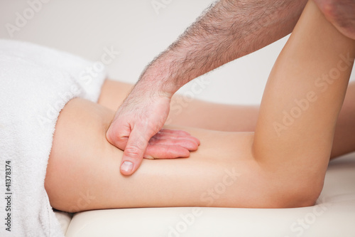 A masseur massaging the thigh of a woman while holding her ankle