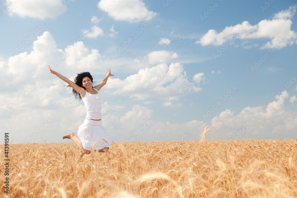 Happy woman jumping in golden wheat Happy woman jumping in golden wheat