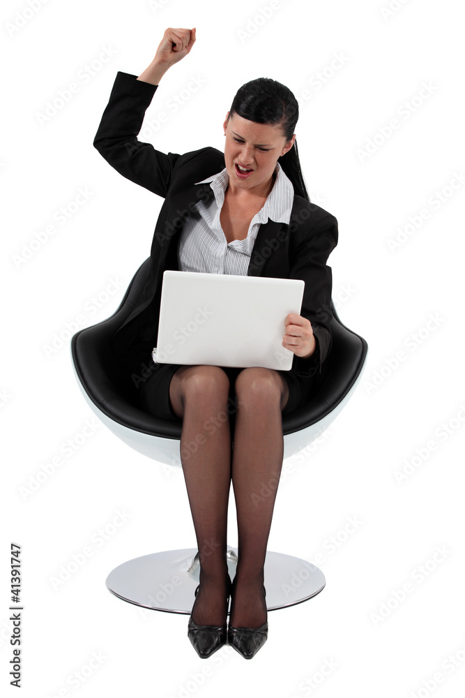 Excited businesswoman pumping fist in the air