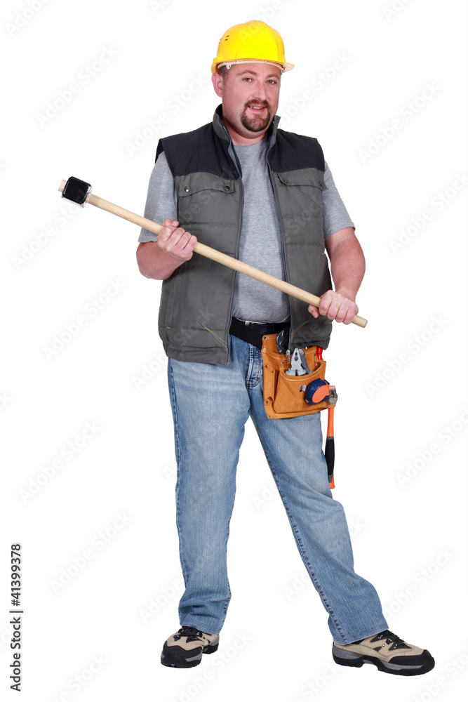 Full-length portrait of a tradesman holding a mallet Full-length portrait of a tradesman holding a mallet