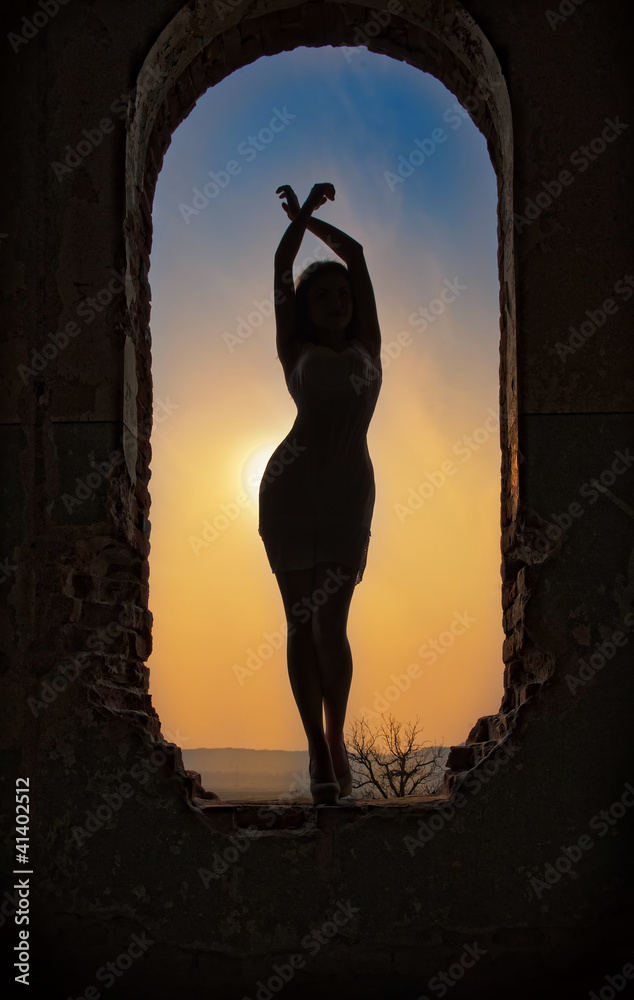 silhouette of a young sensual woman in the window