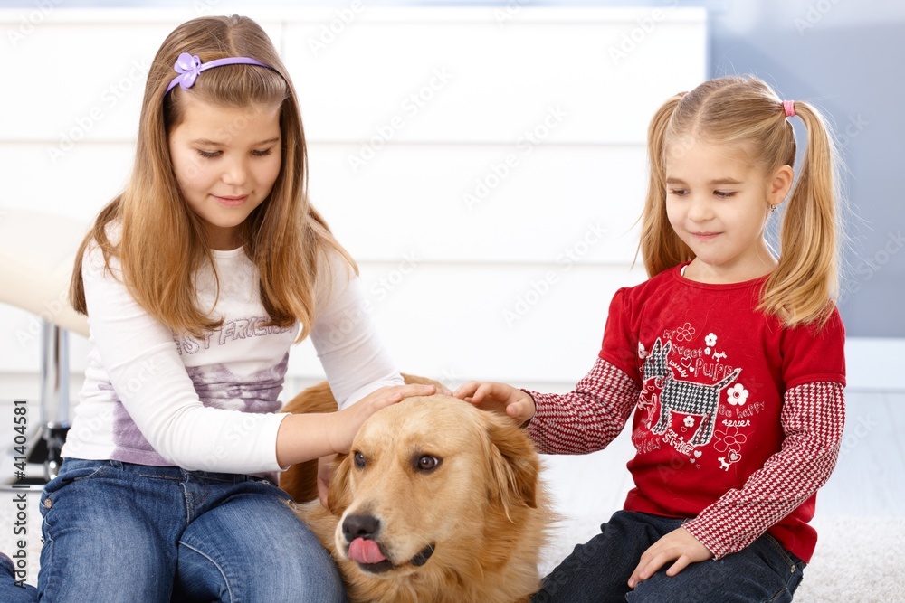Little girls stroking dog smiling