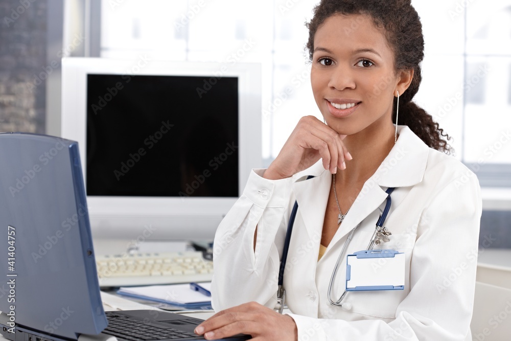 Smiling ethnic doctor with laptop computer Smiling ethnic doctor with laptop computer