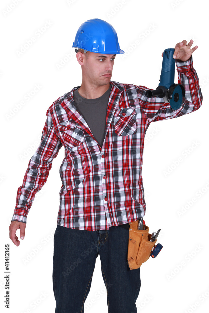 Man reluctantly holding angle grinder Man reluctantly holding angle grinder