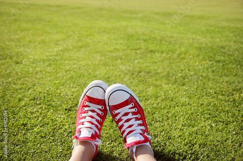 Feet in sneakers in green grass