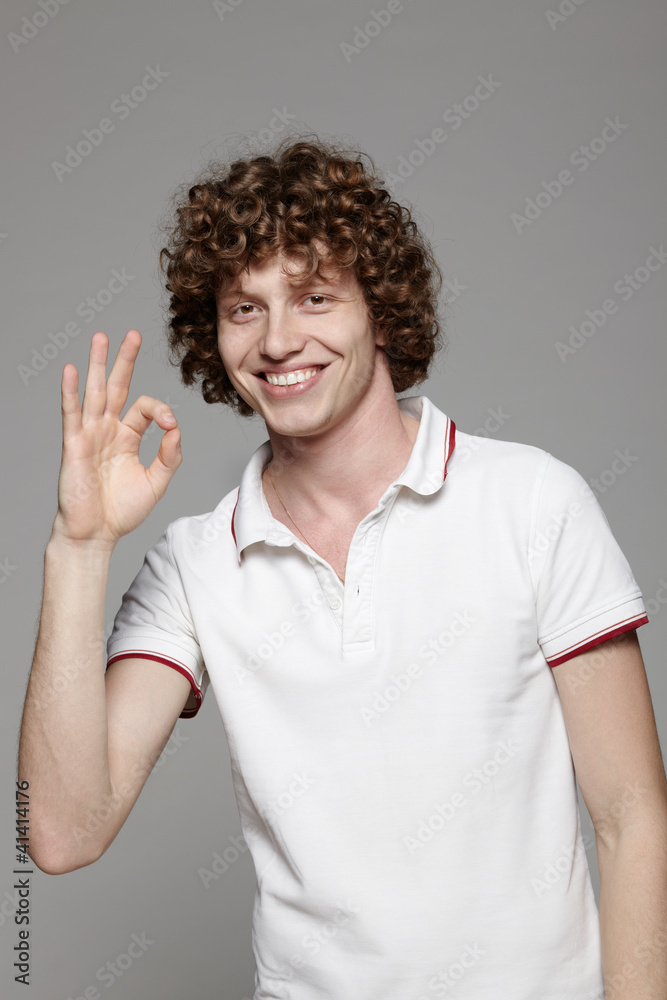 Closeup of smiling young man gesturing okay sign Closeup of smiling young man gesturing okay sign