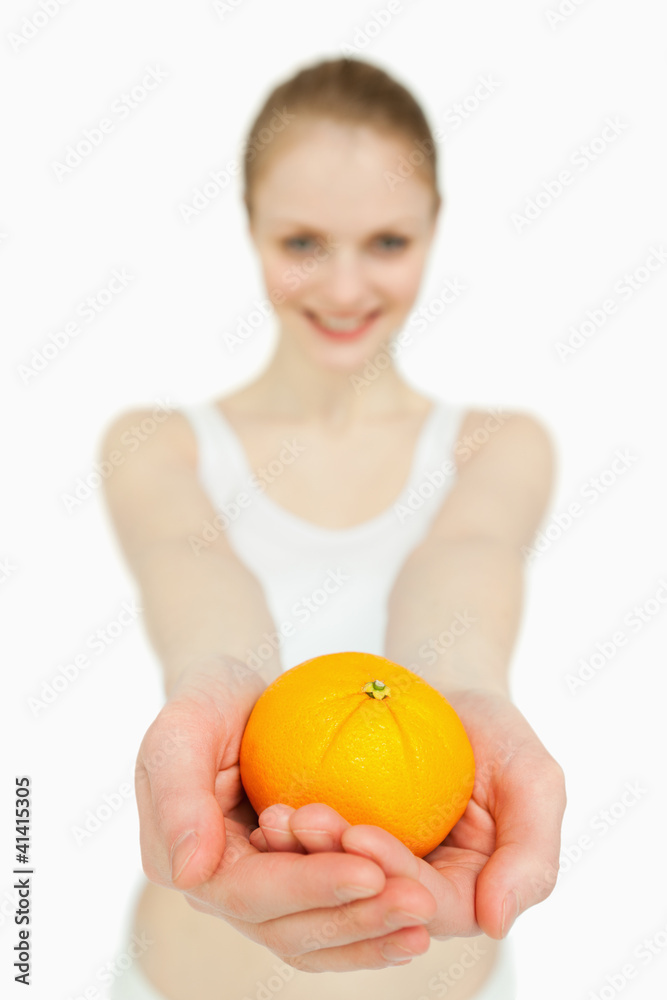 Close up of a woman presenting a tangerine Close up of a woman presenting a tangerine