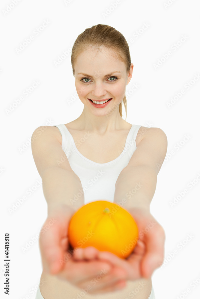 Smiling woman presenting a tangerine Smiling woman presenting a tangerine