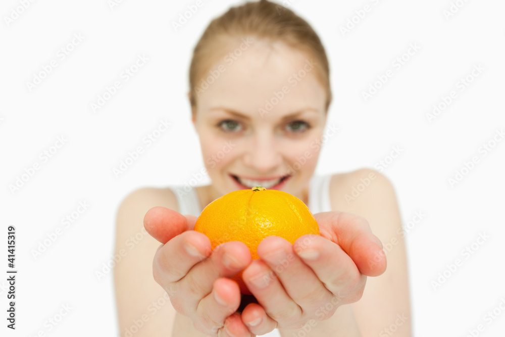 Young woman holding a tangerine Young woman holding a tangerine