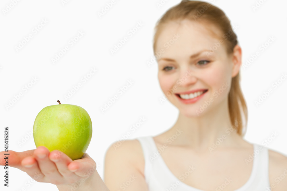 Woman smiling while presenting an apple Woman smiling while presenting an apple