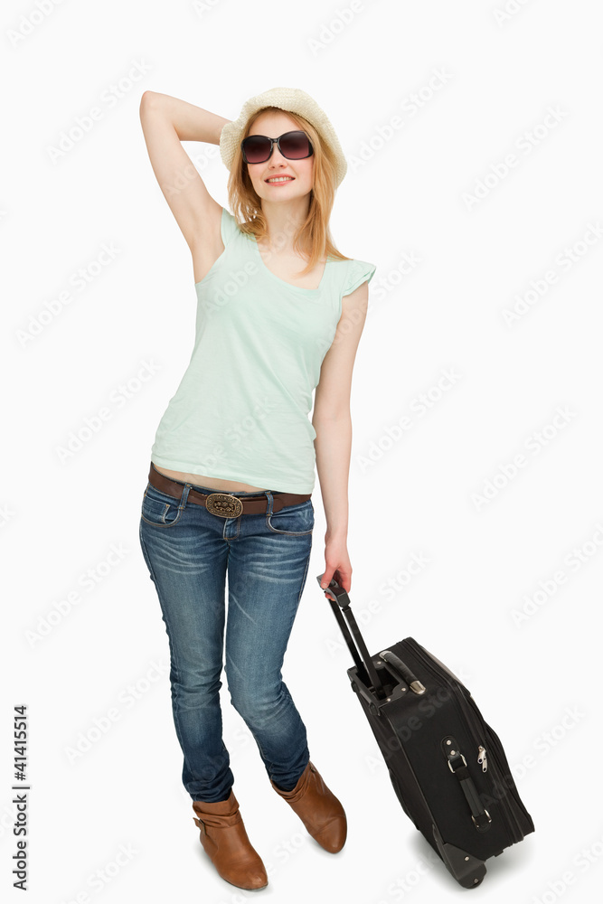 Young woman holding a suitcase while standing Young woman holding a suitcase while standing
