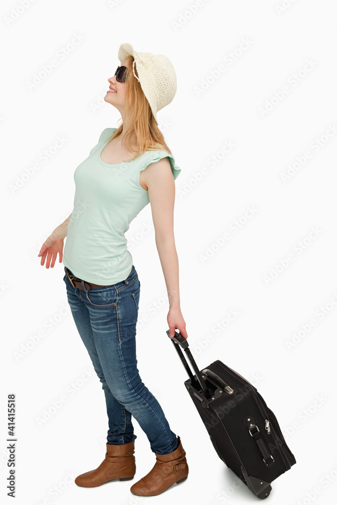 Young woman smiling while holding a suicase Young woman smiling while holding a suicase
