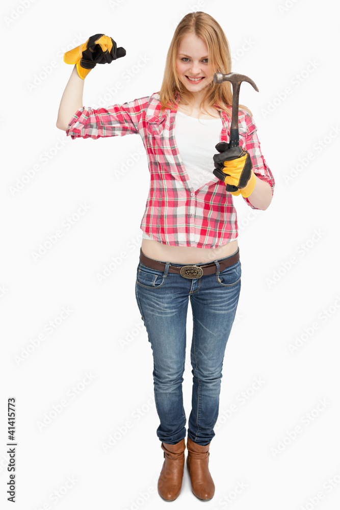 Woman standing while holding a hammer Woman standing while holding a hammer