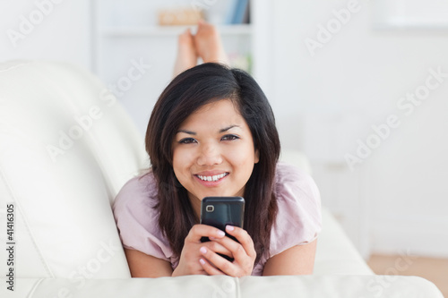 Smiling woman on a couch with a phone in her hands