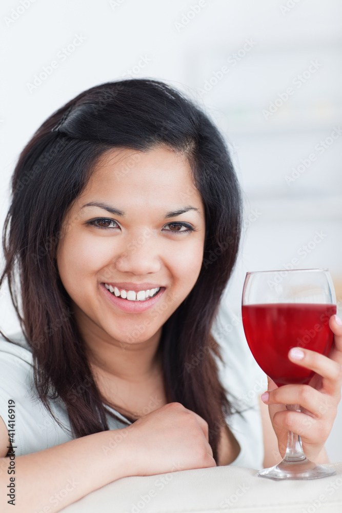 Close-up of a smiling woman holding a glass of red wine