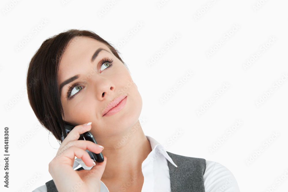 Beautiful businesswoman looking up while phoning Beautiful businesswoman looking up while phoning