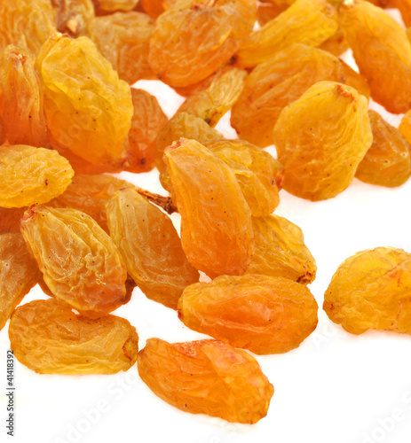 close up of raisins scattered on white background