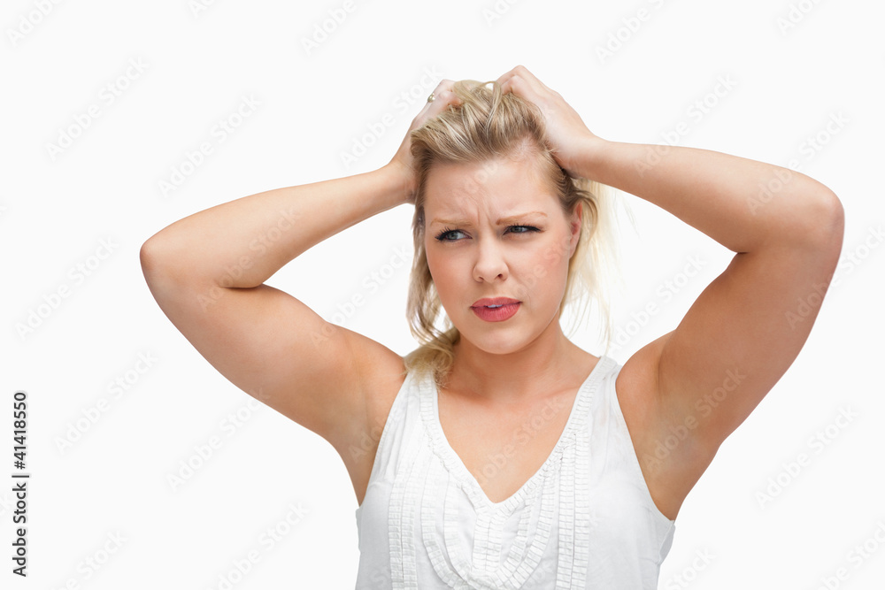 Serious blonde woman placing her hands on her head