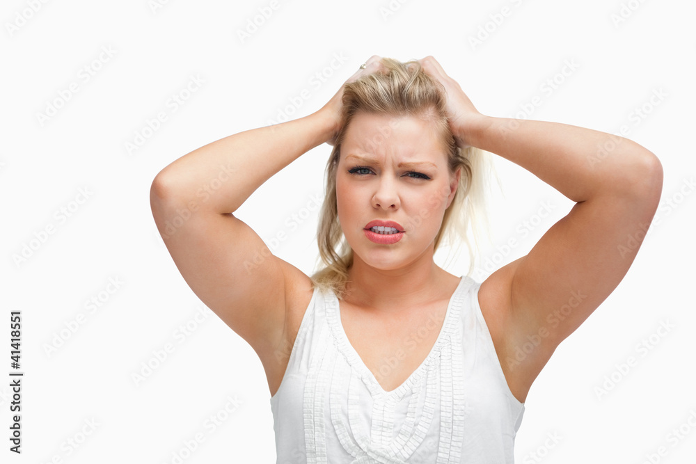 Upset woman standing while placing her hands on her head