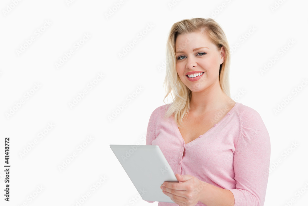 Cheerful blonde woman holding her touchscreen Cheerful blonde woman holding her touchscreen