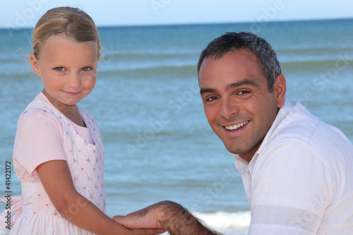 Father and daughter holding hands on the beach