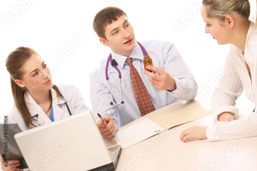 Two doctors making prescription for a patient on white