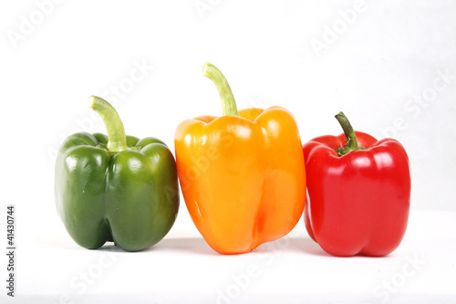 Three color red green yellow peppers in white background