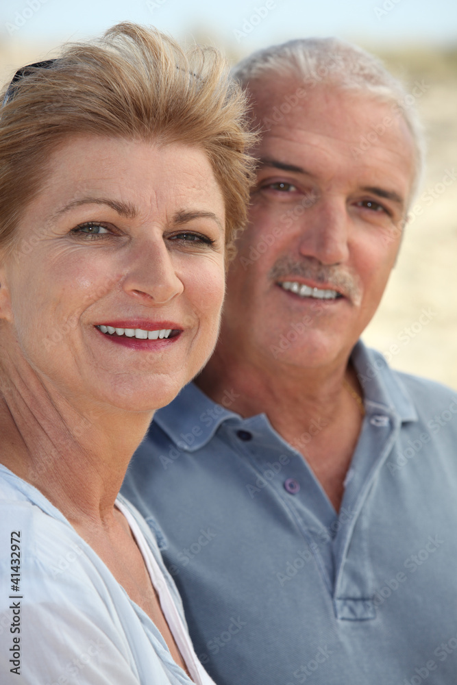 Middle-aged couple stood on beach Middle-aged couple stood on beach